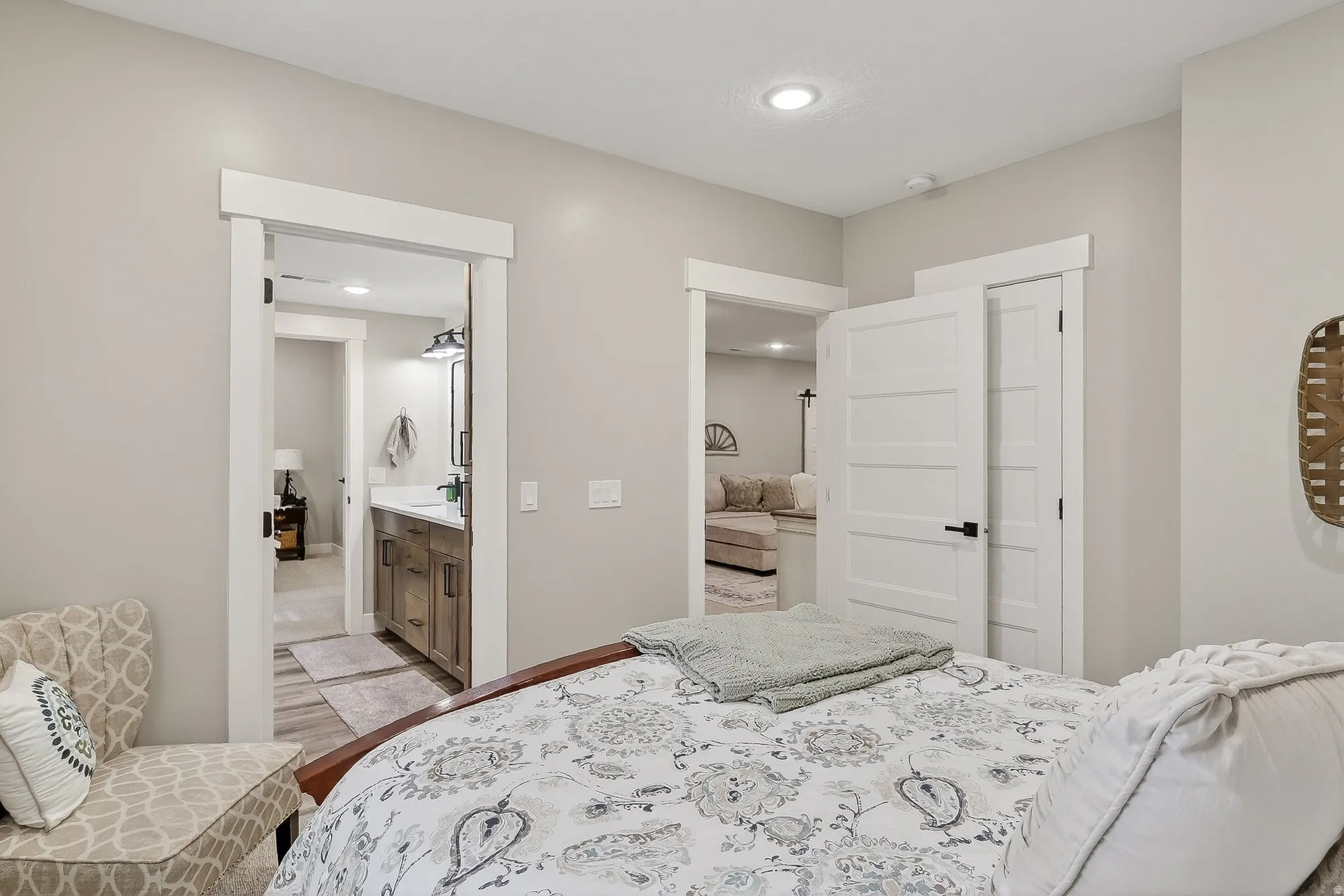 Bedroom featuring light wood finished floors, recessed lighting, and connected bathroom