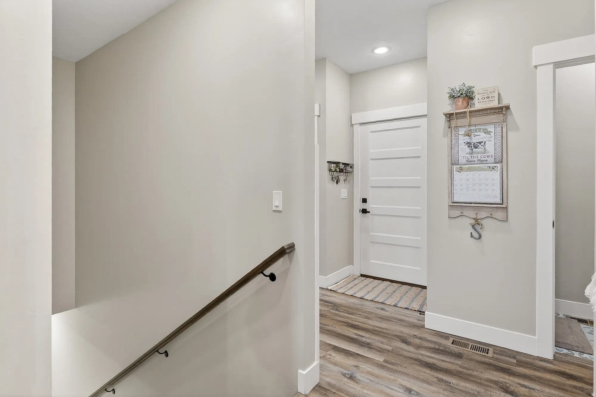 Hall featuring light wood-style flooring and an upstairs landing