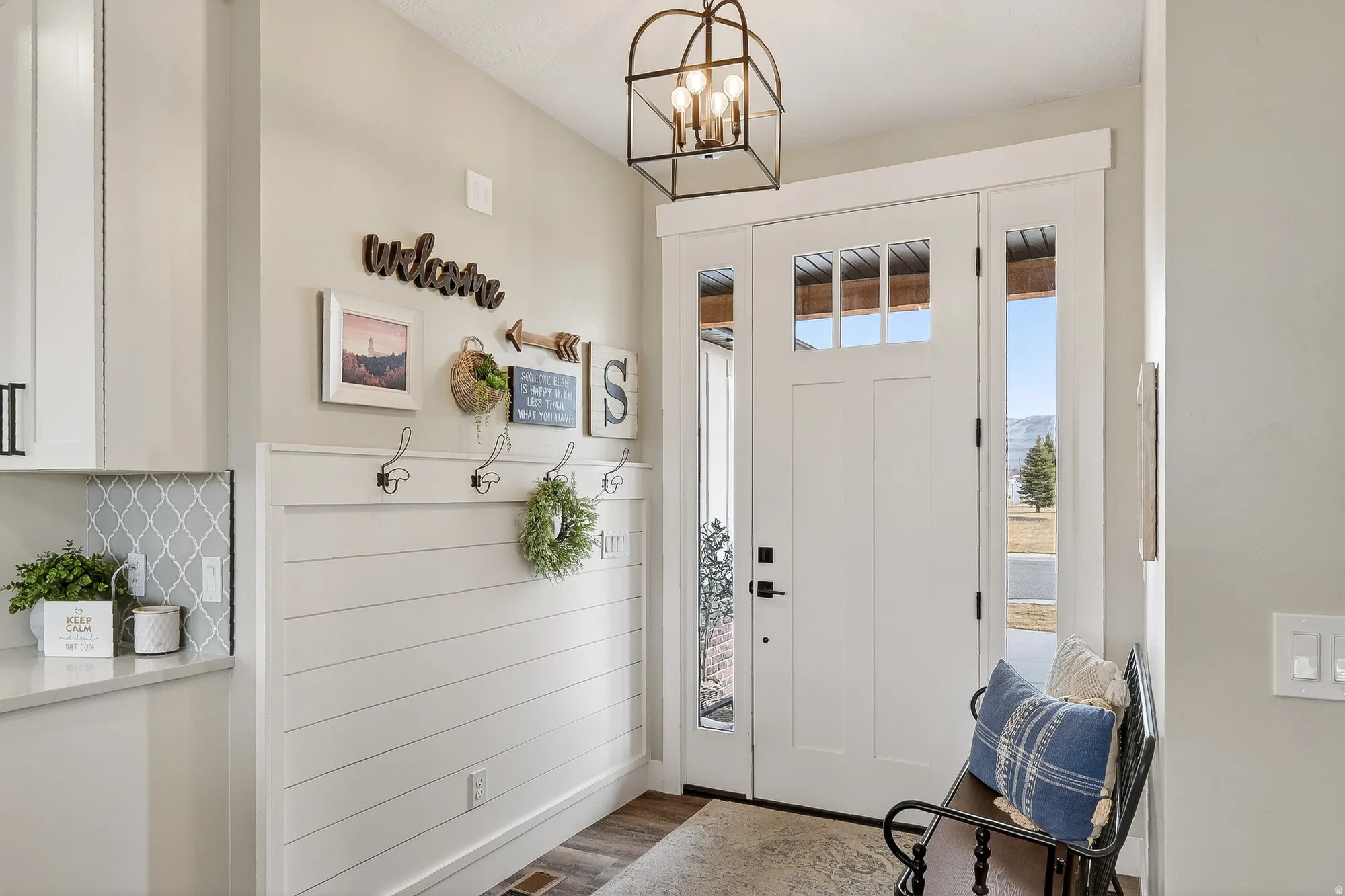 Entryway with dark wood-type flooring and hanging lights