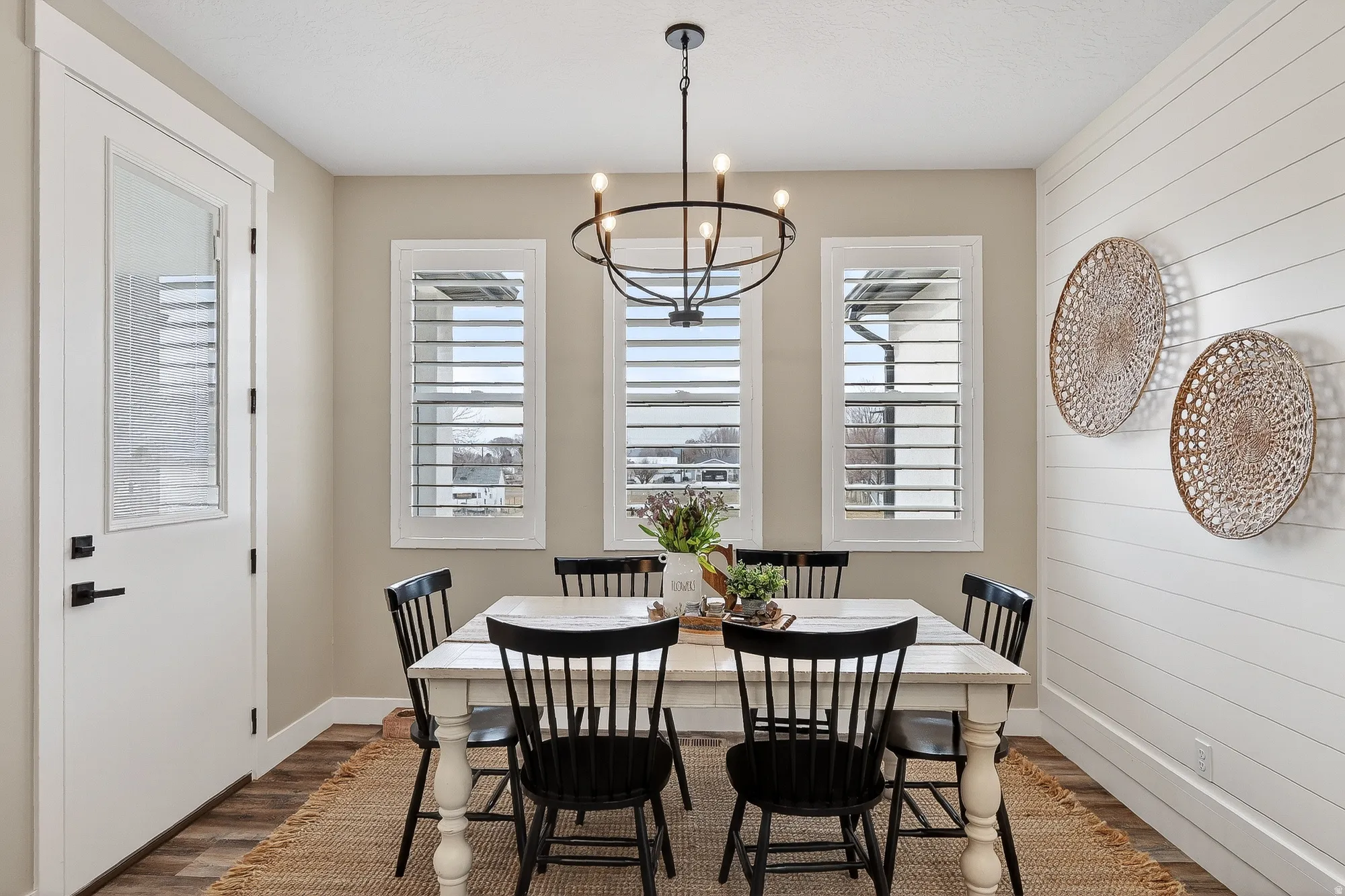 Dining space with hanging lights, dark wood-type flooring, and wooden walls