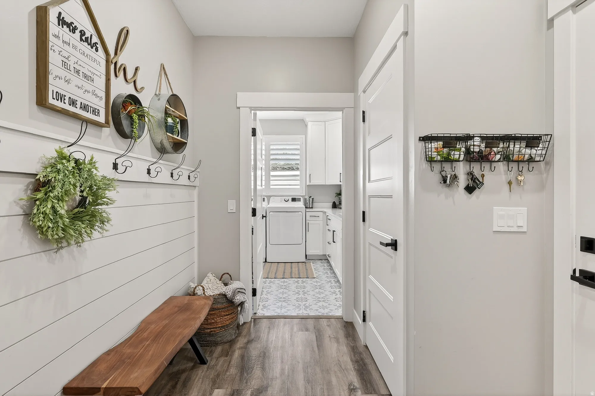 Mudroom with dark wood finished floors and separate washer and dryer
