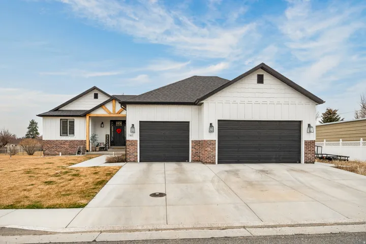 Modern farmhouse style home with board and batten siding, covered porch, concrete driveway, a garage, and roof with shingles