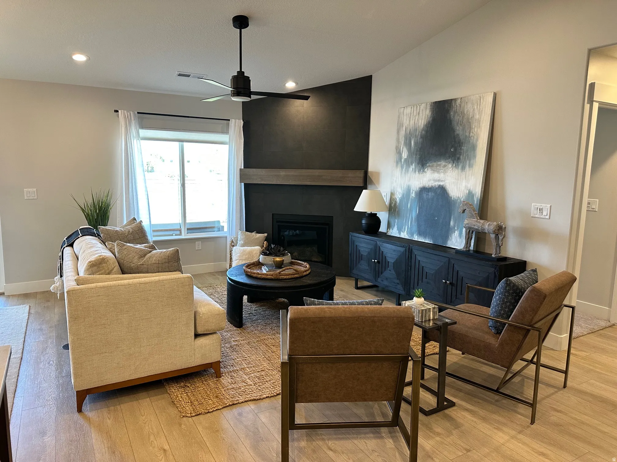 Living room featuring a fireplace, vaulted ceiling, recessed lighting, light wood finished floors, and a ceiling fan