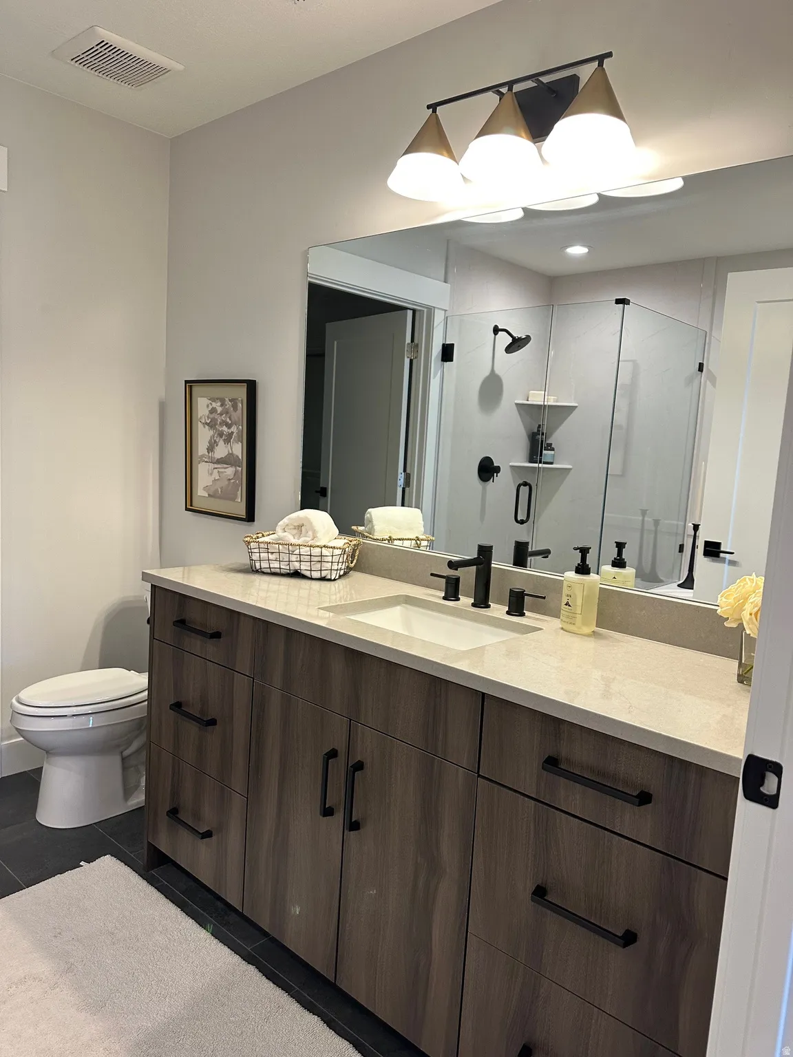 Full bath featuring vanity, a shower stall, and dark tile patterned floors