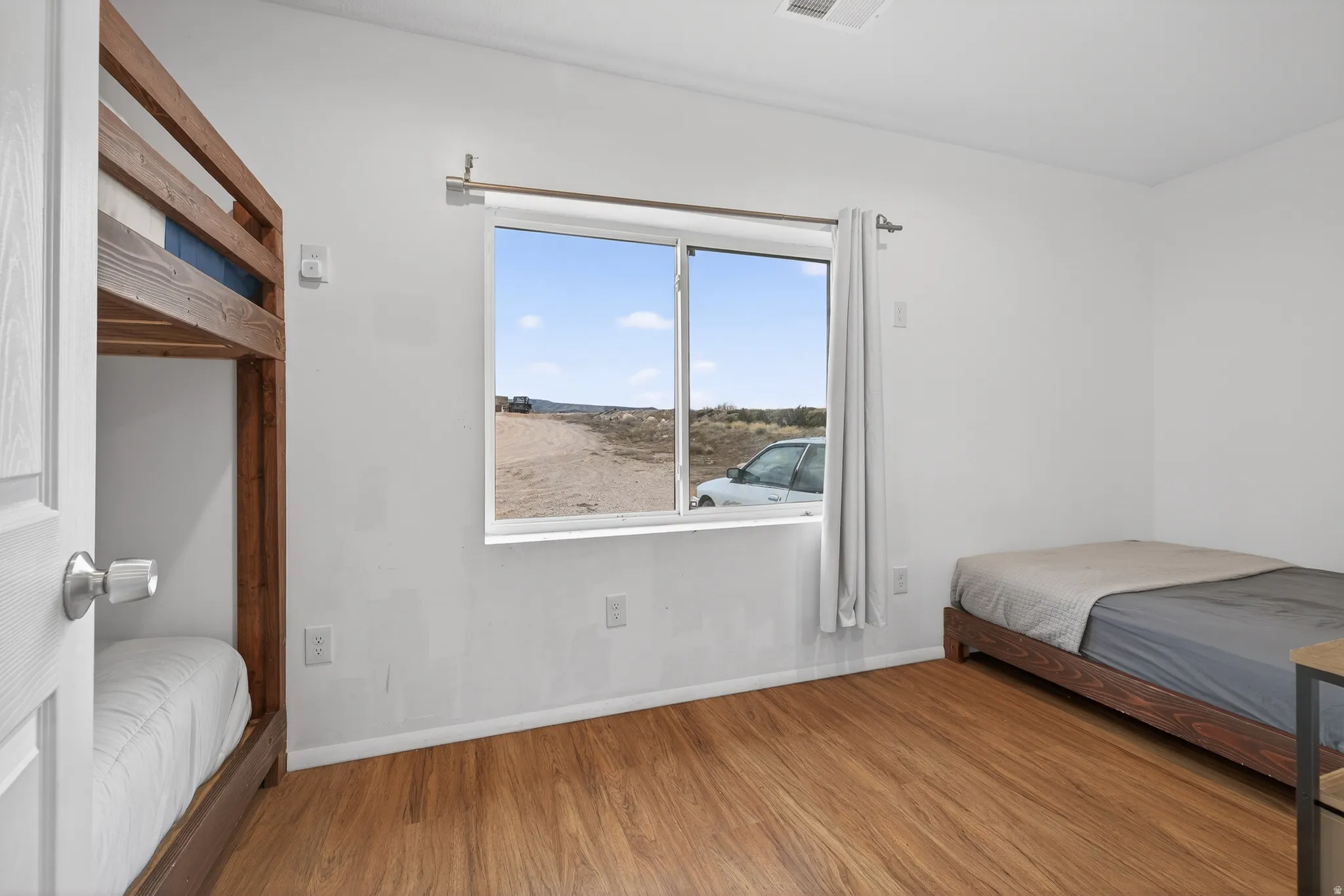 Bedroom with wood finished floors and baseboards