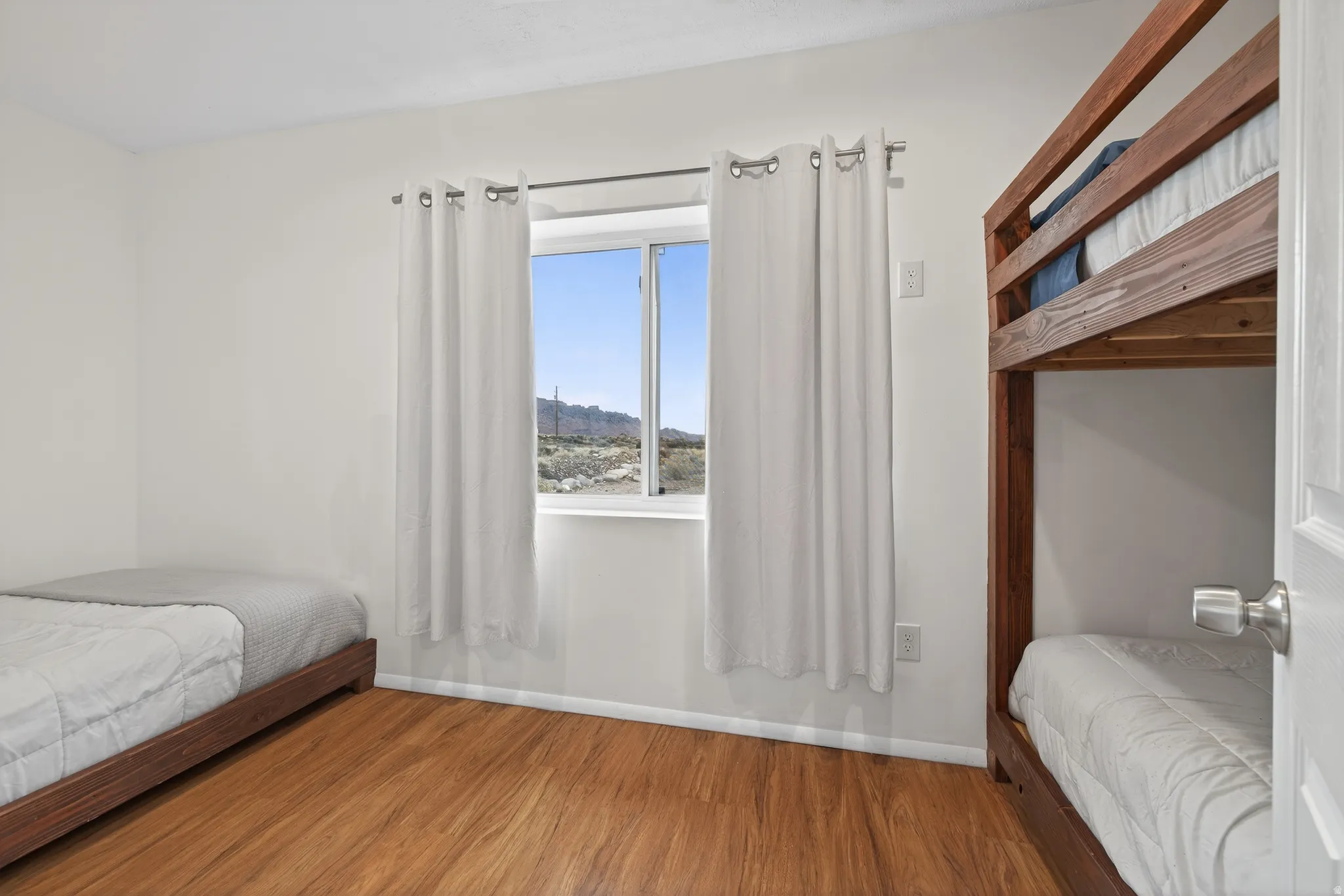 Bedroom featuring wood finished floors and baseboards