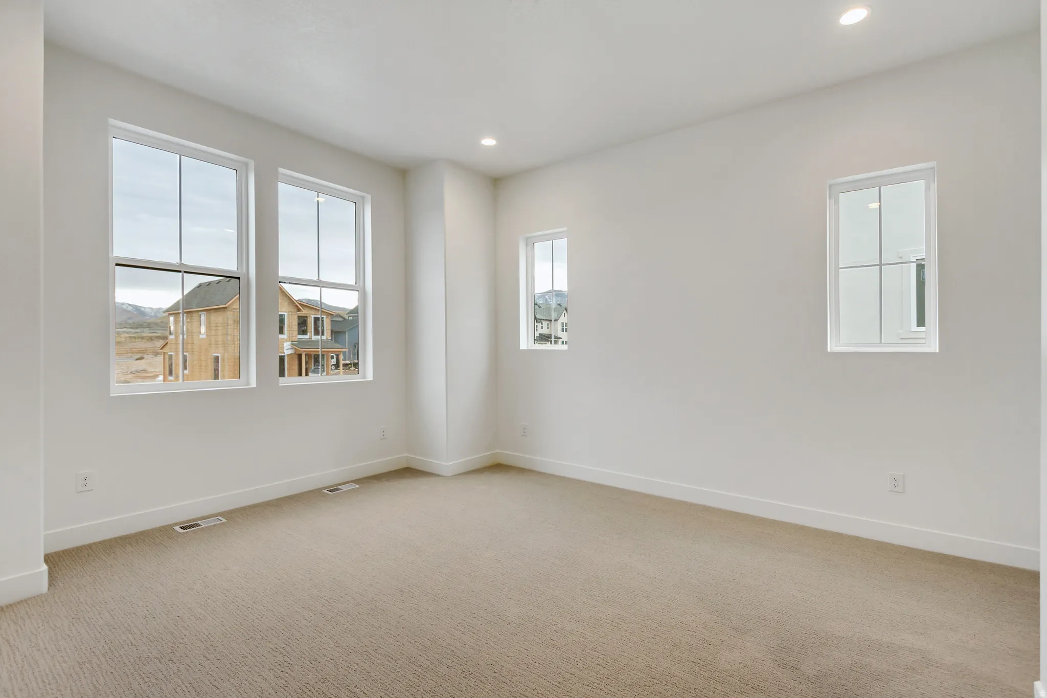 Spare room with light carpet and recessed lighting