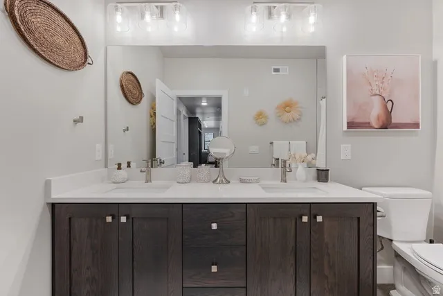 Full bathroom with double vanity and toilet