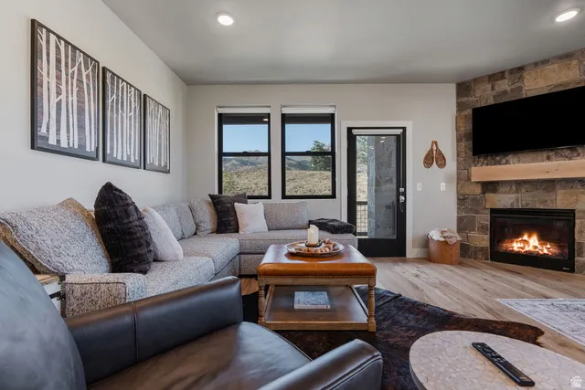 Living room featuring wood finished floors, a fireplace, and recessed lighting