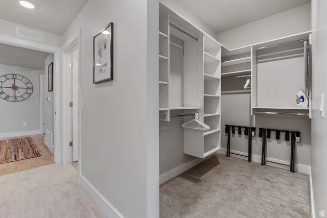Walk in closet featuring light carpet