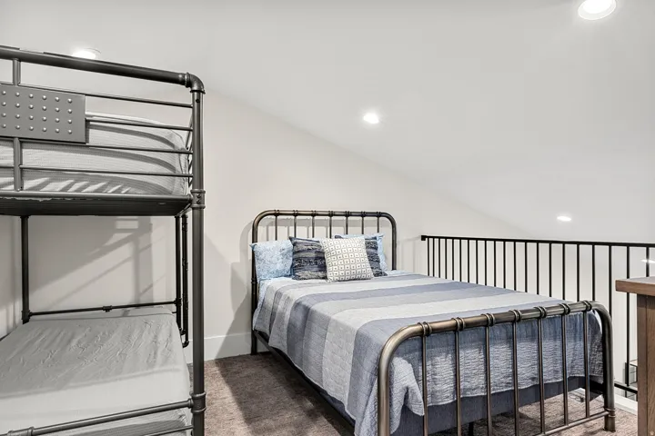 Carpeted bedroom with recessed lighting and vaulted ceiling