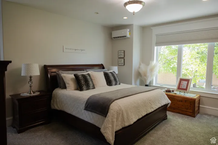 Bedroom featuring carpet flooring, a wall mounted AC, and recessed lighting