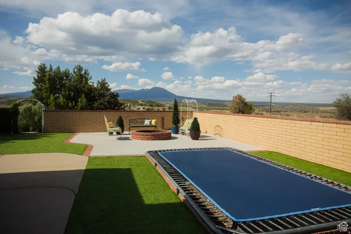 Fenced backyard with a mountain view and a patio area