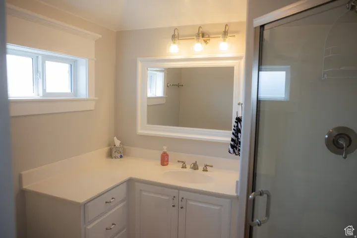 Bathroom featuring vanity, a stall shower, and healthy amount of natural light
