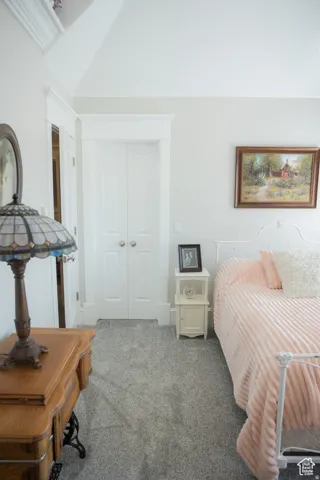 Bedroom featuring carpet floors, a closet, and lofted ceiling