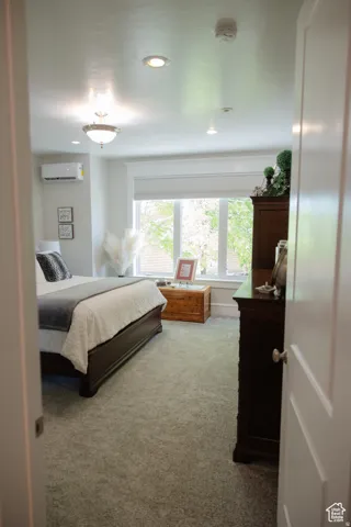 Bedroom with carpet, recessed lighting, and a wall mounted air conditioner