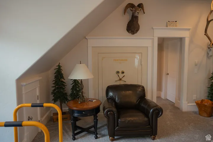 Sitting room with carpet and vaulted ceiling