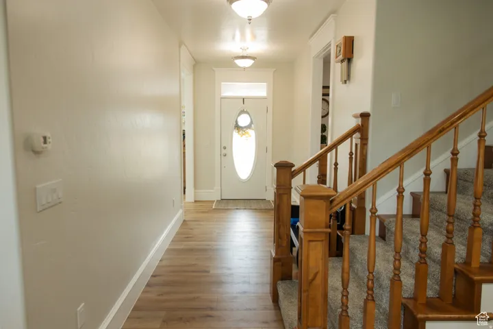 Entryway with light wood-type flooring and stairs