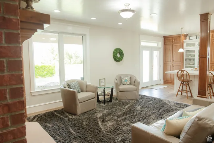 Living area with french doors, light wood finished floors, and recessed lighting