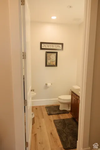 Bathroom with light wood-style floors, vanity, and recessed lighting