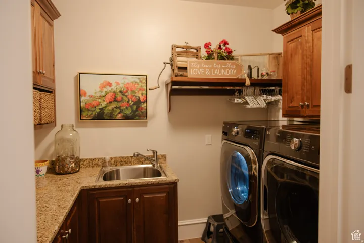 Washroom featuring cabinet space and washing machine and clothes dryer