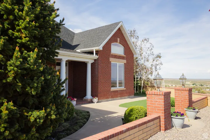View of front of house with a shingled roof and brick siding