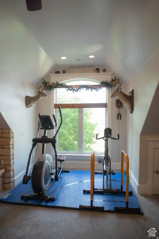 Workout room featuring vaulted ceiling, recessed lighting, and carpet flooring