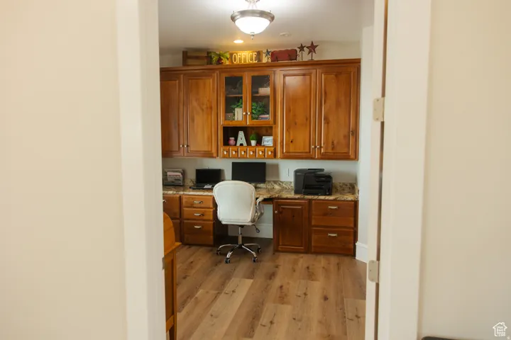 Office space featuring built in study area and light wood-type flooring