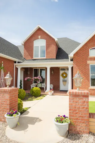 View of front of house featuring roof with shingles, a porch, and brick siding