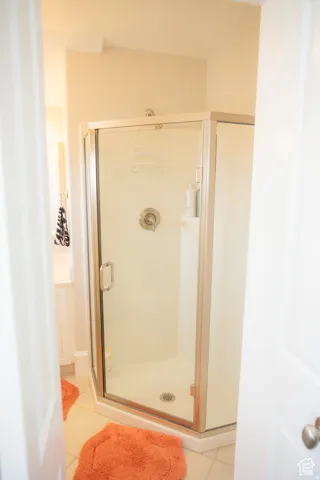Full bath with light tile patterned floors and a stall shower