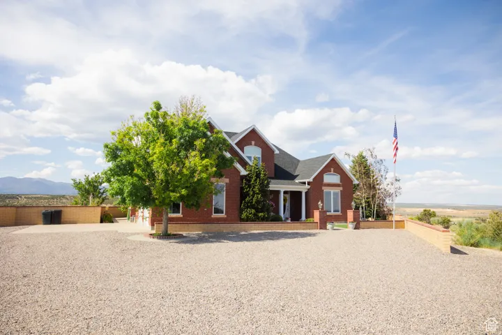 View of front of property with brick siding and roof with shingles