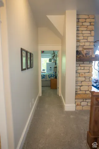 Hall with carpet and vaulted ceiling