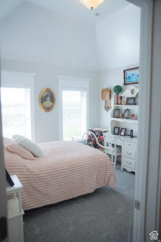 Bedroom featuring multiple windows, carpet floors, and vaulted ceiling