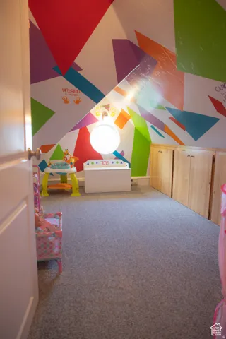 Rec room with carpet and vaulted ceiling