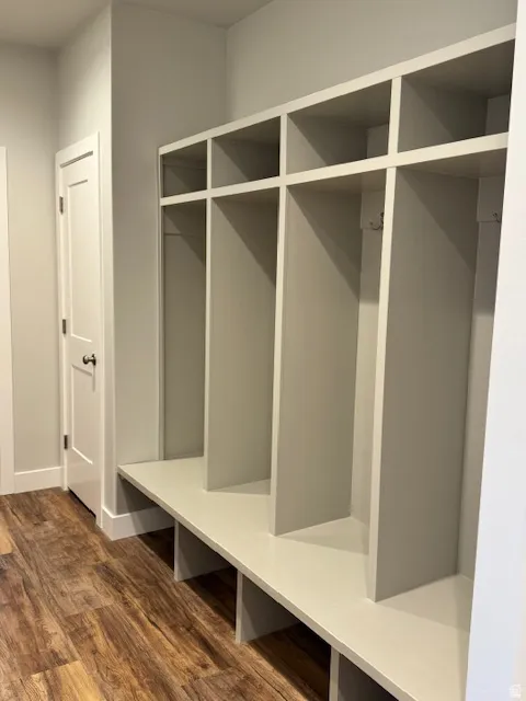 Mudroom featuring dark wood finished floors and closets for coats and shoes