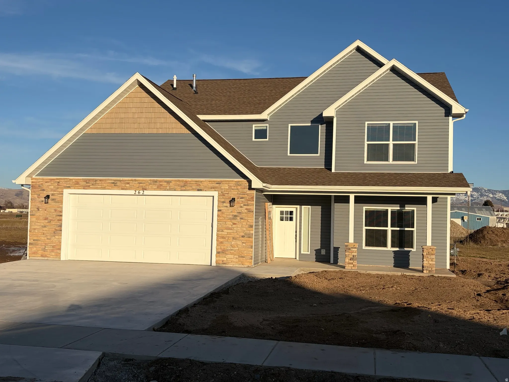Craftsman inspired home with roof with shingles, concrete driveway, and covered porch