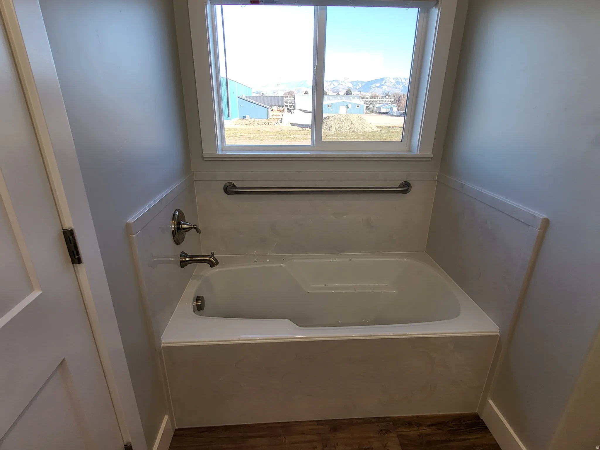 Full bathroom featuring a garden tub and dark wood finished floors