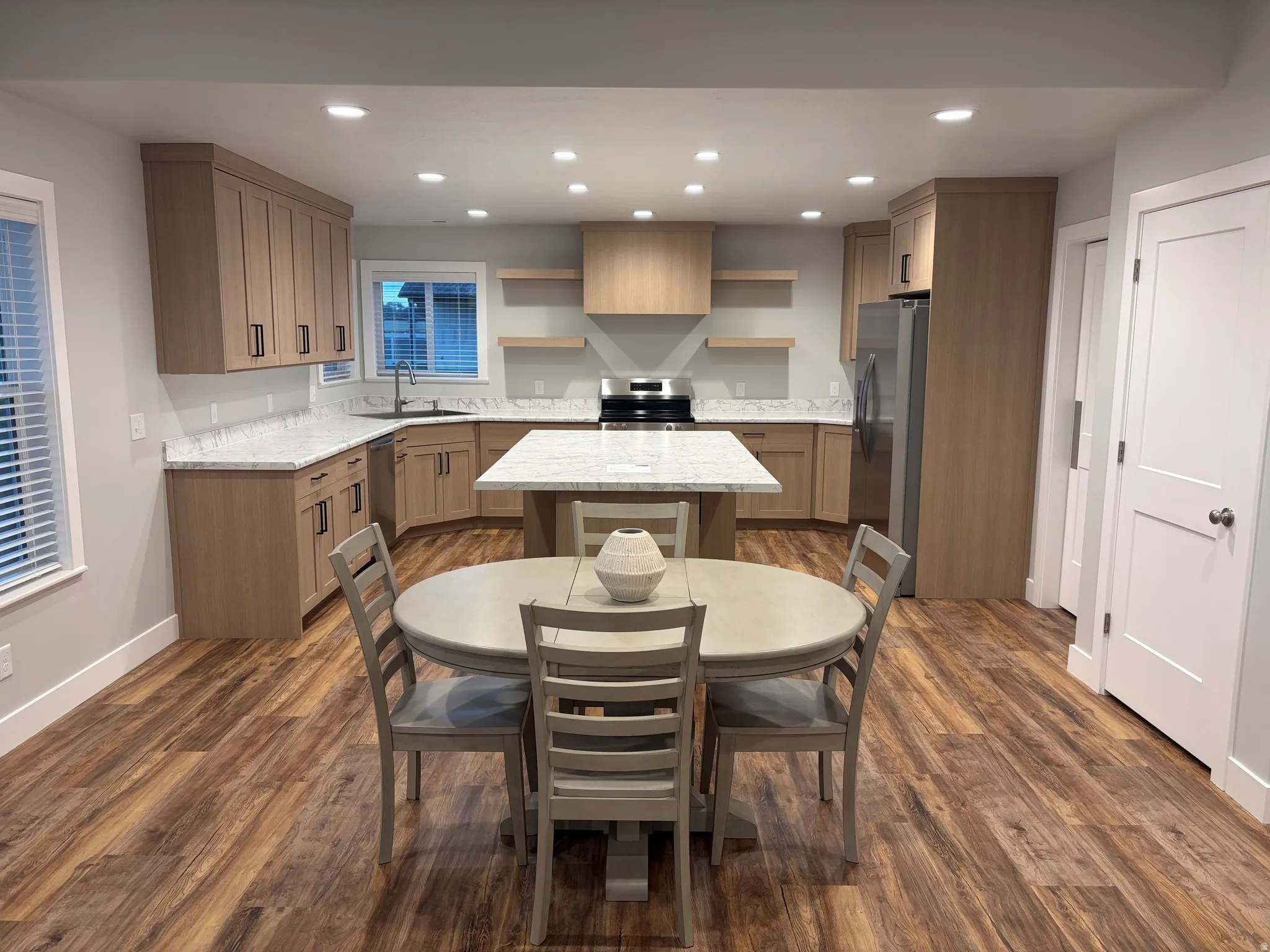 Kitchen with open shelves, light stone counters, a kitchen island, stainless steel appliances, and recessed lighting