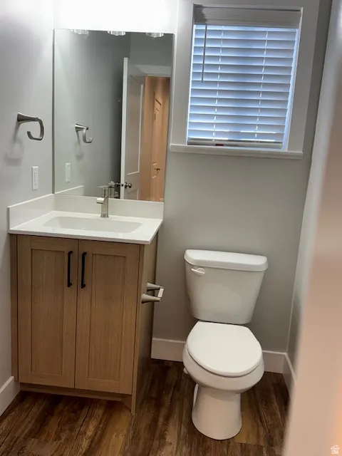 Half bathroom with vanity and dark wood finished floors