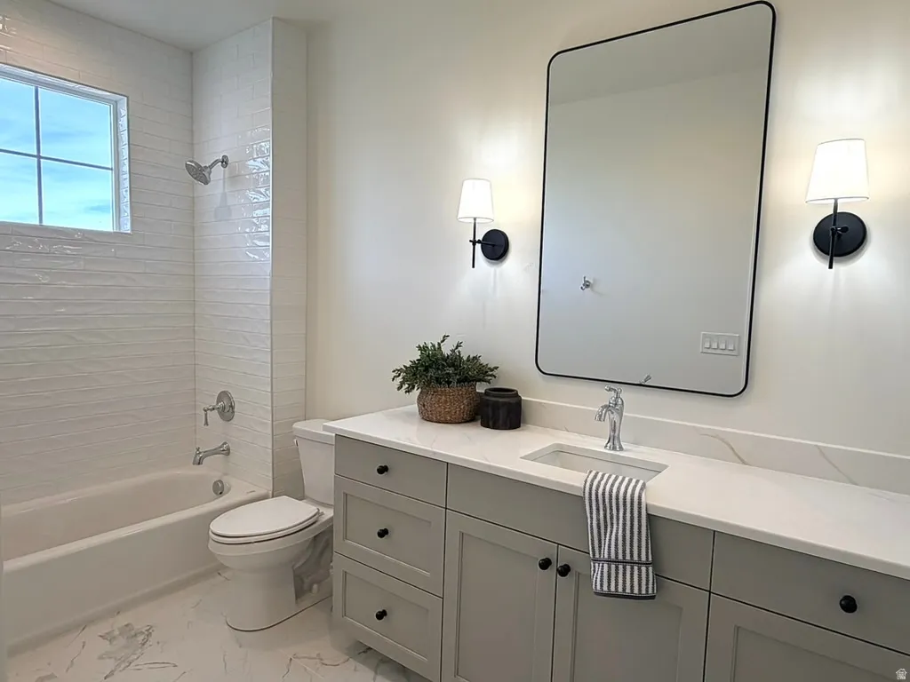 Bathroom featuring vanity, bath tub / shower combination, and tile shower and floors