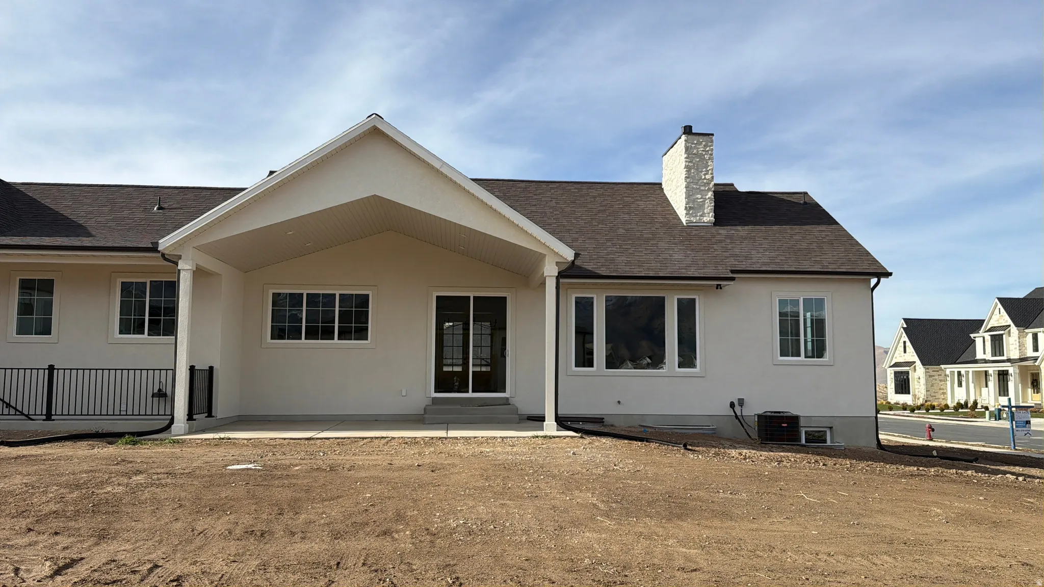 Back of house featuring a chimney, a patio, basement entrance.