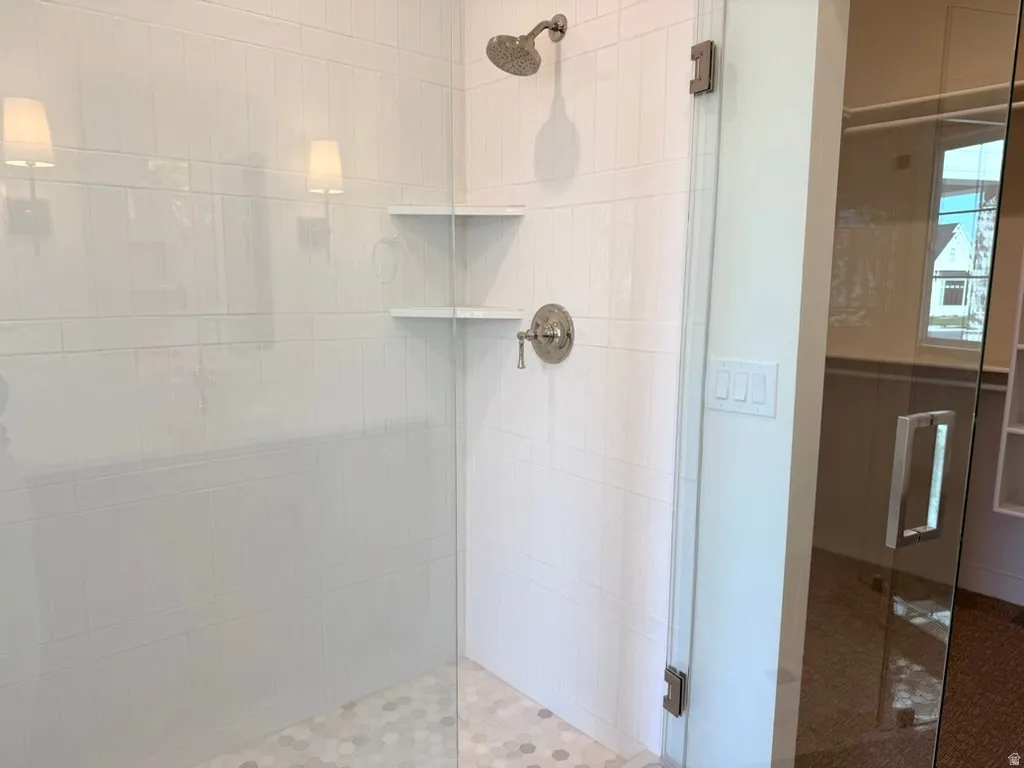Master shower with tile from floor to ceiling surrounded by full euro glass shower.