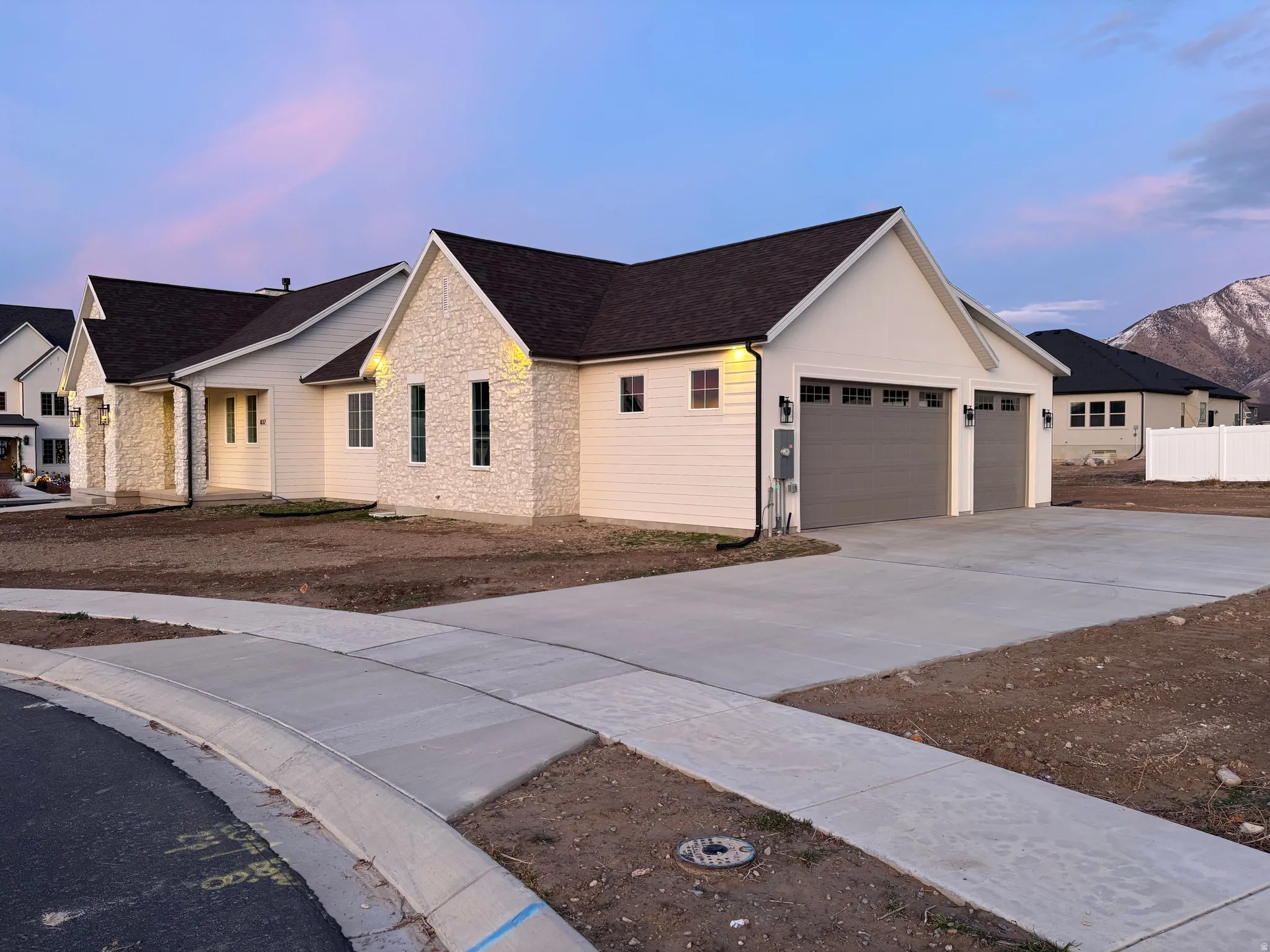 Modern farmhouse style home with concrete driveway, an attached garage, stone siding, and a shingled roof