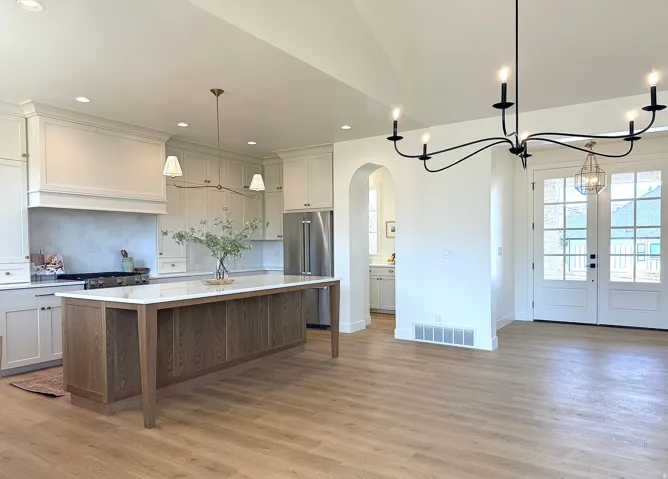 Kitchen featuring a center island, high end refrigerator, arched walkways, hanging light fixtures, and a chandelier