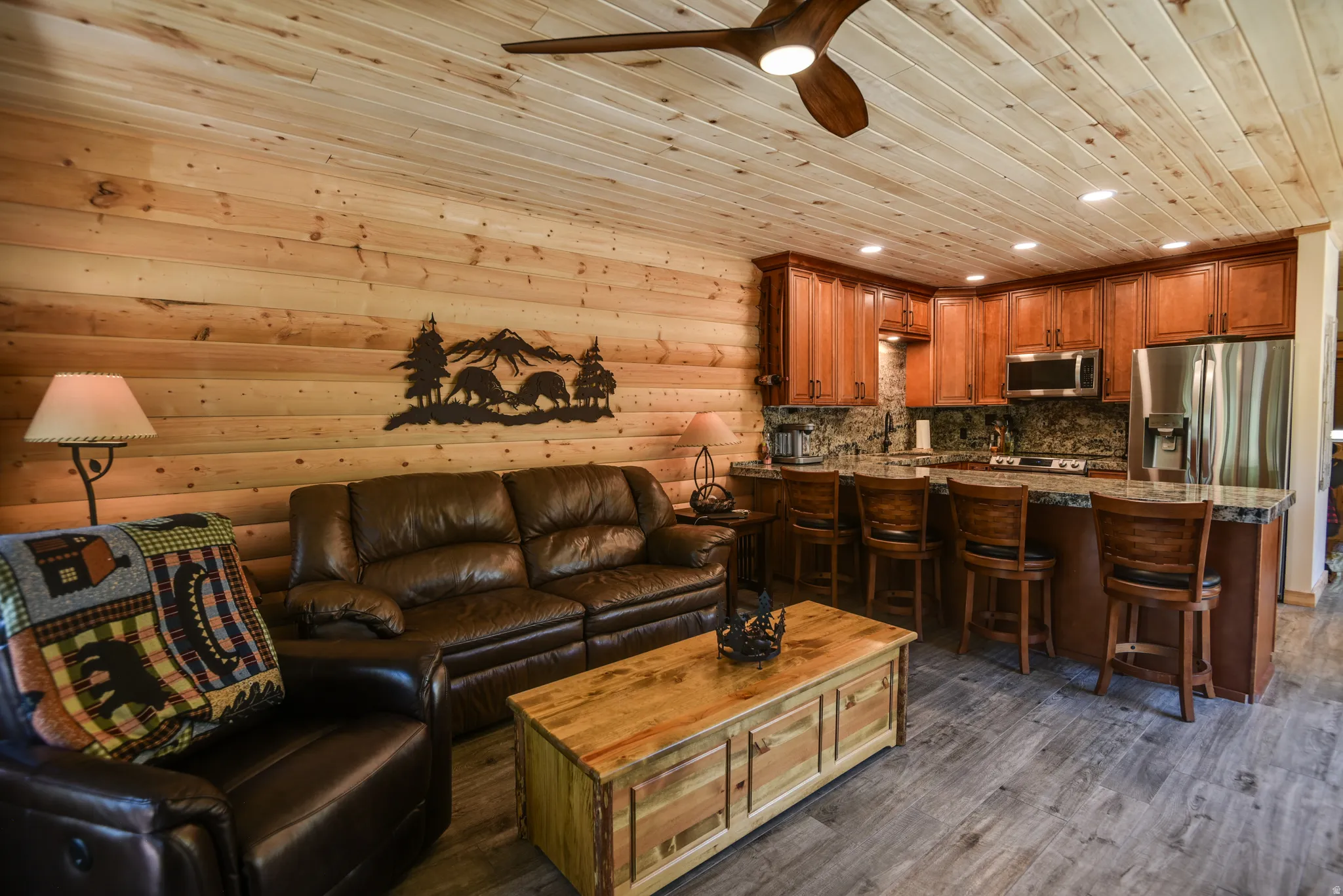 Living area featuring wood ceiling, ceiling fan, dark wood-style floors, recessed lighting, and log walls