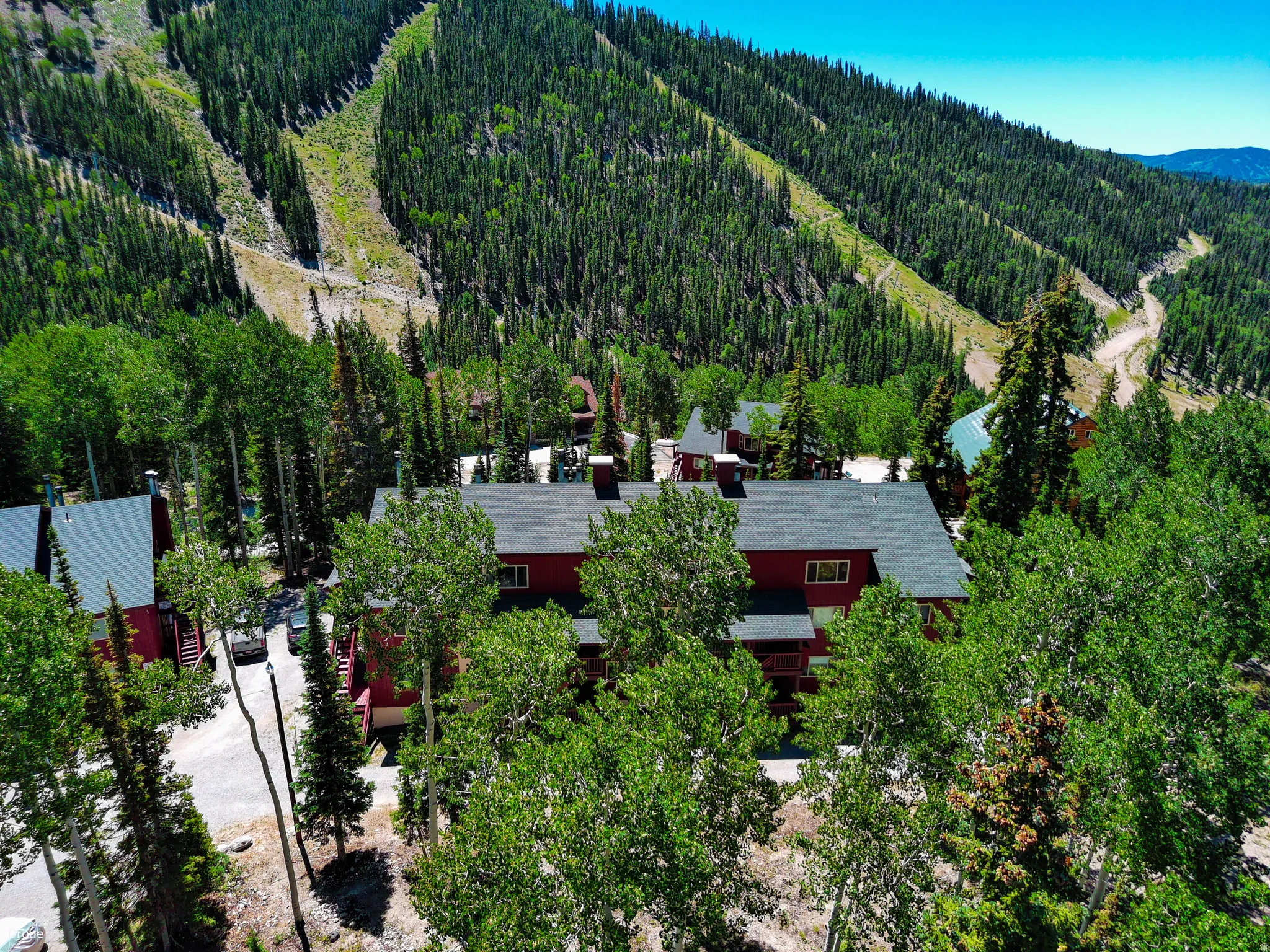 Aerial view of property's location with a heavily wooded area and mountains