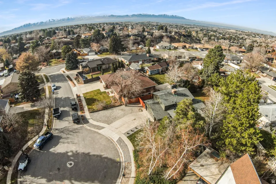 Aerial view of property and surrounding area with nearby suburban area and a mountainous background