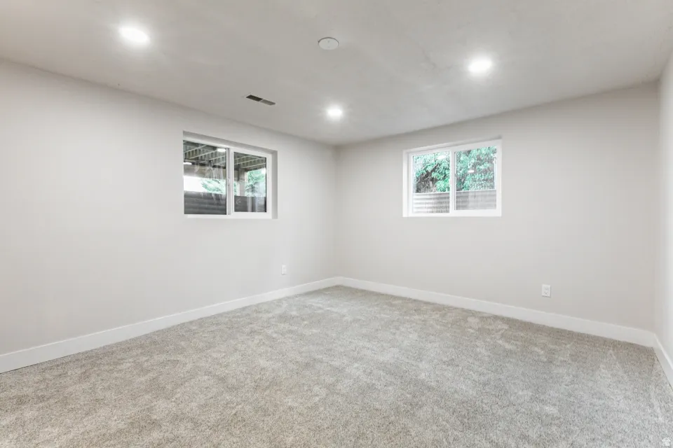 Carpeted empty room featuring baseboards and recessed lighting