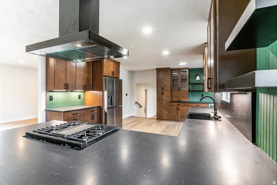 Kitchen with granite countertops, extractor fan, recessed lighting, stainless steel dishwasher, and a peninsula