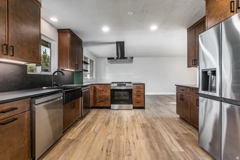 Kitchen with granite countertops, extractor fan, recessed lighting, stainless steel dishwasher, and a peninsula
